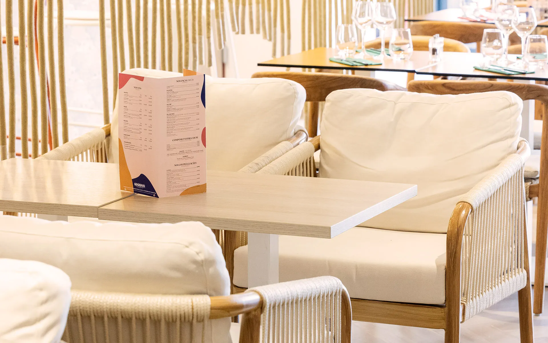 Banquette écrue et menu sur table en bois clair