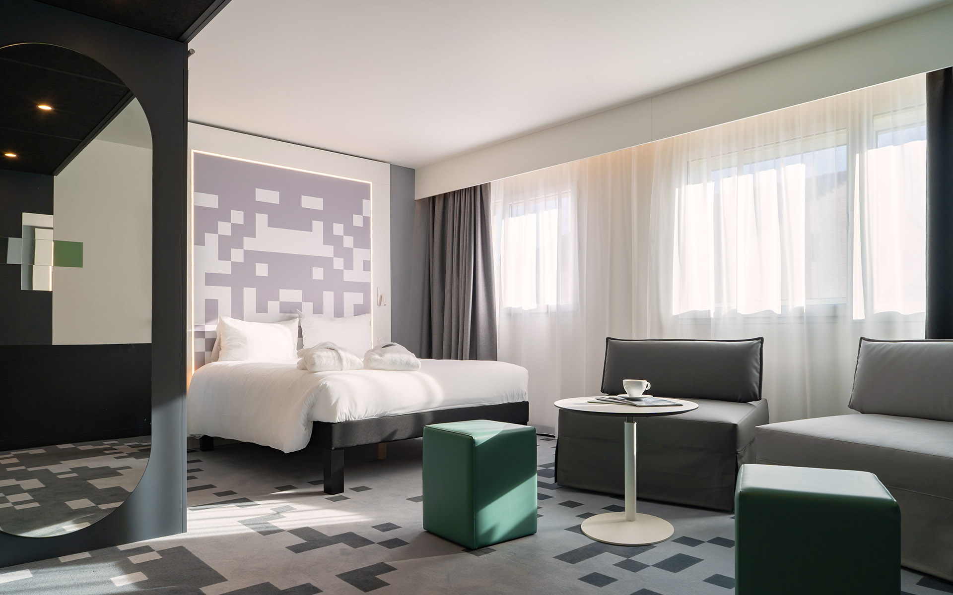 Chambre au mobilier anthracite, tête de lit mauve à motif pixelisé.