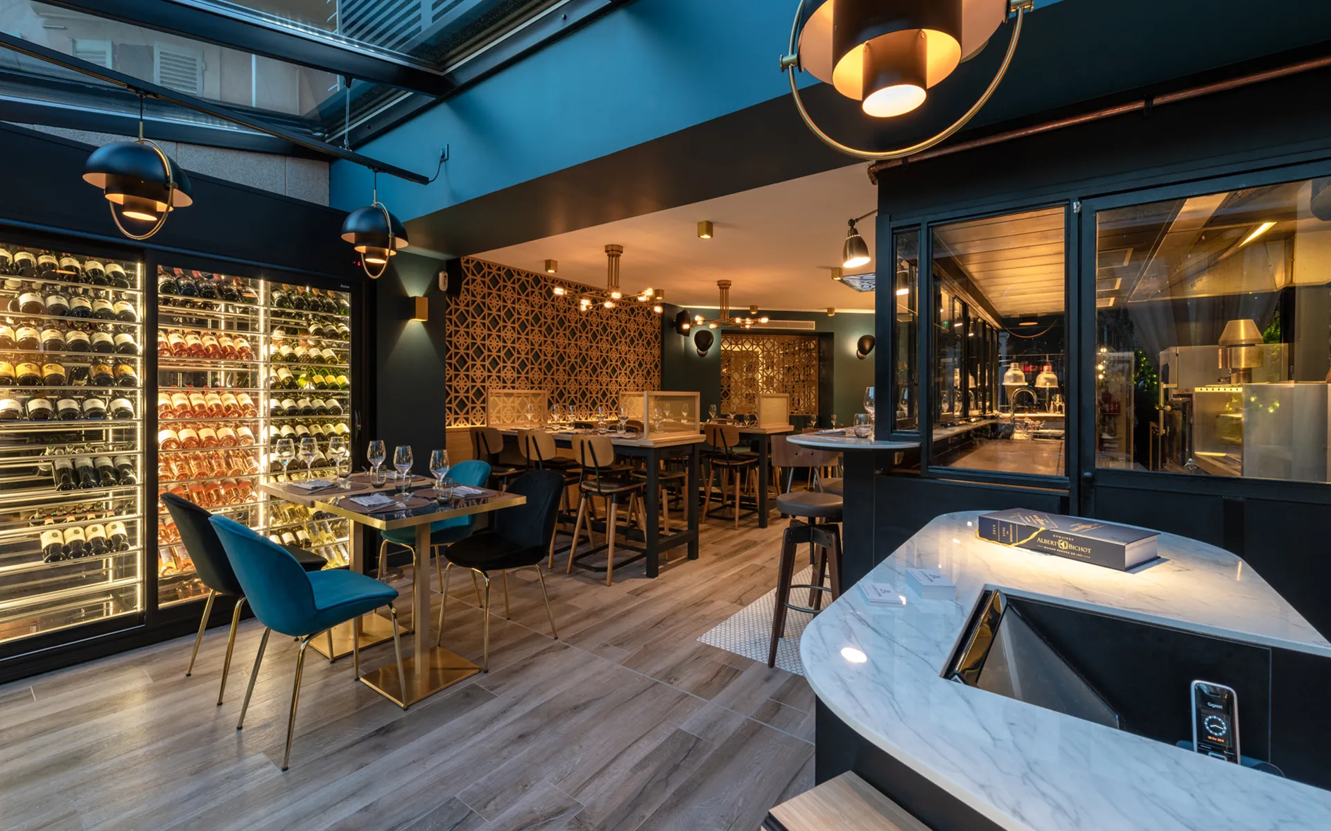 Bar et mur de vitrine à vin, tables en marbre et laiton.